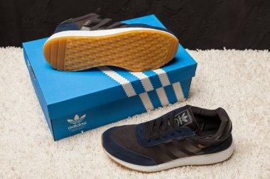 Yeni renkli ve güzel Adidas Iniki koşu ayakkabıları, spor ayakkabıları, spor ayakkabıları, spor ayakkabıları soyut arka planda bir marka kutusu olan logoyu gösteriyor. Spor ve günlük ayakkabı konsepti. Kyiv, Ukrayna-7 Mart 2018
