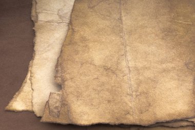 Aged paper sheet. Blank old background with dust and dirty stains. Vintage and antique art concept. Poster mockup. Detailed closeup studio shot. Front view. Toned