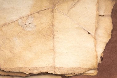 Aged paper sheet. Blank old background with dust and dirty stains. Vintage and antique art concept. Poster mockup. Detailed closeup studio shot. Front view. Toned