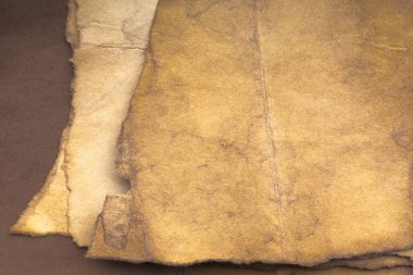 Aged paper sheet. Blank old background with dust and dirty stains. Vintage and antique art concept. Poster mockup. Detailed closeup studio shot. Front view. Toned
