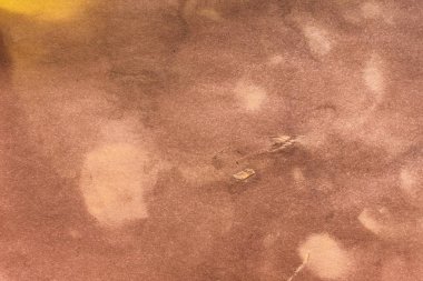 Aged paper sheet. Blank old background with dust and dirty stains. Vintage and antique art concept. Poster mockup. Detailed closeup studio shot. Front view. Toned