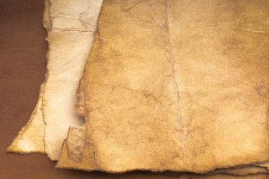 Aged paper sheet. Blank old background with dust and dirty stains. Vintage and antique art concept. Poster mockup. Detailed closeup studio shot. Front view. Toned