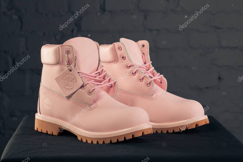 New beautiful colorful and nice Timberland tracking shoes, sneakers, trainers shows logo with a brand box on abstract background. Sport and casual footwear concept. Kyiv, Ukraine-November 16, 2017
