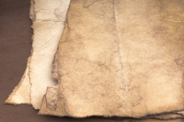 Aged paper sheet. Blank old background with dust and dirty stains. Vintage and antique art concept. Poster mockup. Detailed closeup studio shot. Front view. Toned