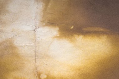Aged paper sheet. Blank old background with dust and dirty stains. Vintage and antique art concept. Poster mockup. Detailed closeup studio shot. Front view. Toned