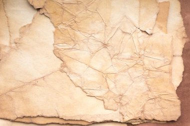 Aged paper sheet. Blank old background with dust and dirty stains. Vintage and antique art concept. Poster mockup. Detailed closeup studio shot. Front view. Toned