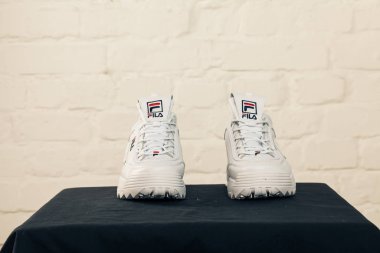 Yeni renkli ve güzel Fila Disruptor koşu ayakkabıları, spor ayakkabıları, spor ayakkabıları, spor ayakkabıları soyut arka planda bir marka kutusu olan logoyu gösteriyor. Spor ve günlük ayakkabı konsepti. Kyiv, Ukrayna - 28 Ocak 2018