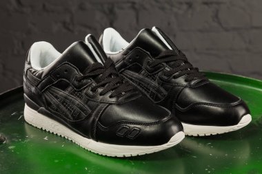 Yeni güzel renkli ve güzel Asics jeli koşu ayakkabıları, spor ayakkabıları, spor ayakkabıları soyut arka planda bir marka kutusu olan logoyu gösteriyor. Spor ve günlük ayakkabı konsepti. Kyiv, Ukrayna - 20 Ekim 2017