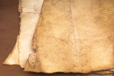 Aged paper sheet. Blank old background with dust and dirty stains. Vintage and antique art concept. Poster mockup. Detailed closeup studio shot. Front view. Toned