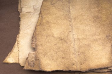 Aged paper sheet. Blank old background with dust and dirty stains. Vintage and antique art concept. Poster mockup. Detailed closeup studio shot. Front view. Toned