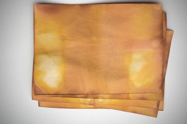 Aged paper sheet. Blank old background with dust and dirty stains. Vintage and antique art concept. Poster mockup. Detailed closeup studio shot. Front view. Toned