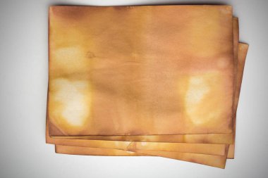 Aged paper sheet. Blank old background with dust and dirty stains. Vintage and antique art concept. Poster mockup. Detailed closeup studio shot. Front view. Toned