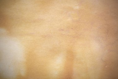 Aged paper sheet. Blank old background with dust and dirty stains. Vintage and antique art concept. Poster mockup. Detailed closeup studio shot. Front view. Toned