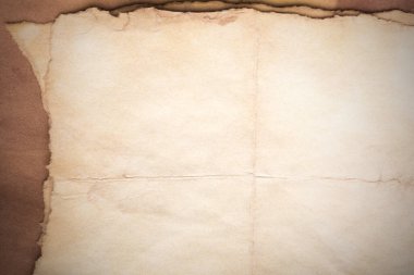 Aged paper sheet. Blank old background with dust and dirty stains. Vintage and antique art concept. Poster mockup. Detailed closeup studio shot. Front view. Toned