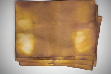 Aged paper sheet. Blank old background with dust and dirty stains. Vintage and antique art concept. Poster mockup. Detailed closeup studio shot. Front view. Toned