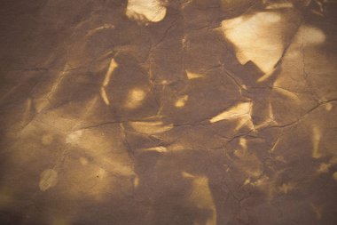 Aged paper sheet. Blank old background with dust and dirty stains. Vintage and antique art concept. Poster mockup. Detailed closeup studio shot. Front view. Toned