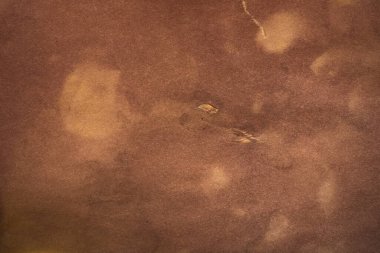 Aged paper sheet. Blank old background with dust and dirty stains. Vintage and antique art concept. Poster mockup. Detailed closeup studio shot. Front view. Toned