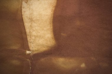 Aged paper sheet. Blank old background with dust and dirty stains. Vintage and antique art concept. Poster mockup. Detailed closeup studio shot. Front view. Toned
