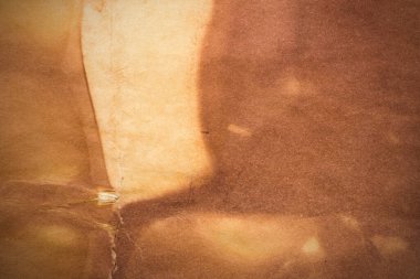 Aged paper sheet. Blank old background with dust and dirty stains. Vintage and antique art concept. Poster mockup. Detailed closeup studio shot. Front view. Toned