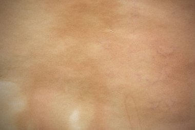 Aged paper sheet. Blank old background with dust and dirty stains. Vintage and antique art concept. Poster mockup. Detailed closeup studio shot. Front view. Toned