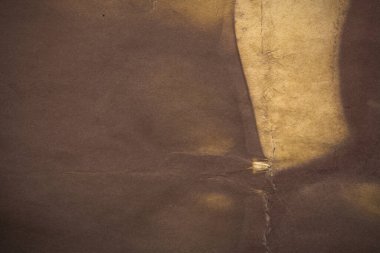 Aged paper sheet. Blank old background with dust and dirty stains. Vintage and antique art concept. Poster mockup. Detailed closeup studio shot. Front view. Toned