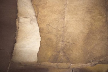 Aged paper sheet. Blank old background with dust and dirty stains. Vintage and antique art concept. Poster mockup. Detailed closeup studio shot. Front view. Toned