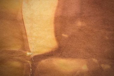 Aged paper sheet. Blank old background with dust and dirty stains. Vintage and antique art concept. Poster mockup. Detailed closeup studio shot. Front view. Toned