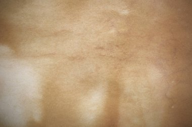 Aged paper sheet. Blank old background with dust and dirty stains. Vintage and antique art concept. Poster mockup. Detailed closeup studio shot. Front view. Toned