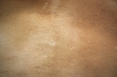 Aged paper sheet. Blank old background with dust and dirty stains. Vintage and antique art concept. Poster mockup. Detailed closeup studio shot. Front view. Toned