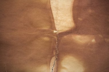 Aged paper sheet. Blank old background with dust and dirty stains. Vintage and antique art concept. Poster mockup. Detailed closeup studio shot. Front view. Toned