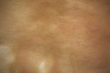 Aged paper sheet. Blank old background with dust and dirty stains. Vintage and antique art concept. Poster mockup. Detailed closeup studio shot. Front view. Toned