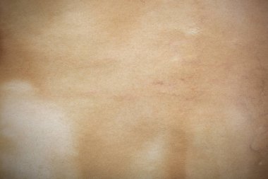 Aged paper sheet. Blank old background with dust and dirty stains. Vintage and antique art concept. Poster mockup. Detailed closeup studio shot. Front view. Toned