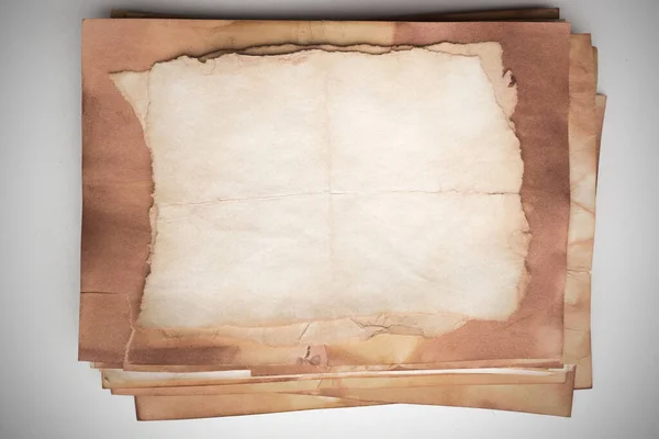 Aged paper sheet. Blank old background with dust and dirty stains. Vintage and antique art concept. Poster mockup. Detailed closeup studio shot. Front view. Toned
