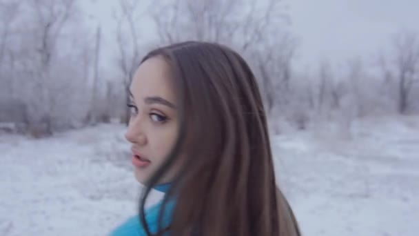 Όμορφη χαριτωμένο κορίτσι με μακριά μαλλιά ποζάρει μέσα στο δάσος του χειμώνα. — Αρχείο Βίντεο