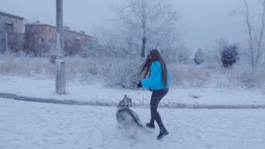 Parkın içinden çalışan köpek ile kız.