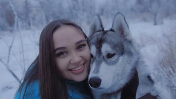 Güzel kız bir husky köpek sarılma. — Stok video