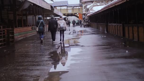 Три людини ходити між торгових павільйонів. — стокове відео
