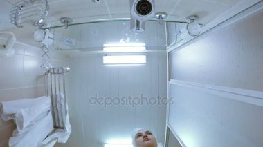 Beyaz bir sabahlık bir duş odasında bir kız.