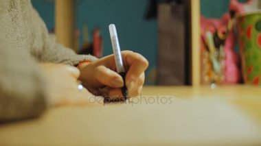Genç bir kadın bir albümde boyama.