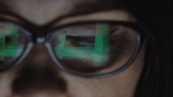 Närbild av en kvinnas ögon med glasögon. En kvinna ser på tabletten. — Stockvideo