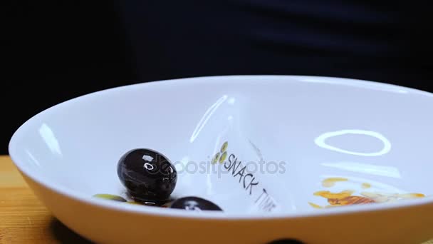 Las aceitunas negras se exponen en platos blancos . — Vídeo de stock