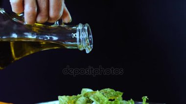 Bir cam kase salata zeytin yağı dökülen.