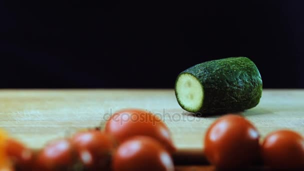 Uma mulher corta um pepino com uma faca de cozinha . — Vídeo de Stock