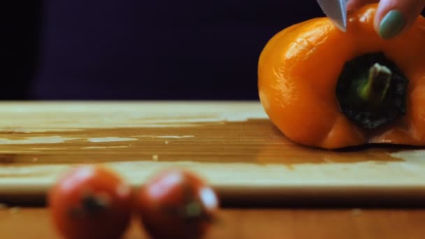 Жінка ріже апельсиновий болгарський перець. Повільний рух . — стокове відео