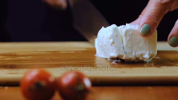Una mujer está cortando queso blanco Feta. Movimiento lento . — Vídeos de Stock