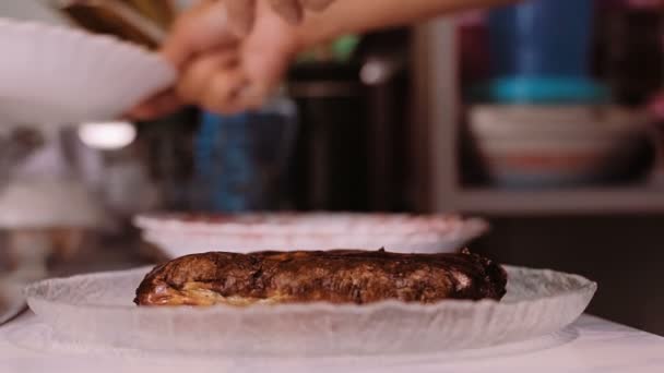 Женщина готовит жареные сосиски на тарелках. . — стоковое видео