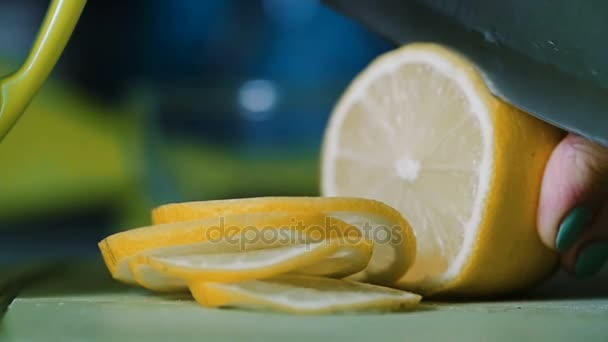 З лимона, що лежить на столі, ніж відрізають ножем . — стокове відео