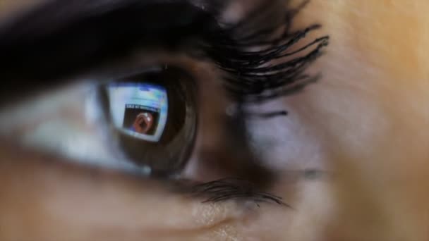 Fotografía macro. El ojo de una mujer que mira la tableta . — Vídeo de stock