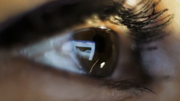 Fotografía macro. El ojo de una mujer que mira la tableta . — Vídeo de stock