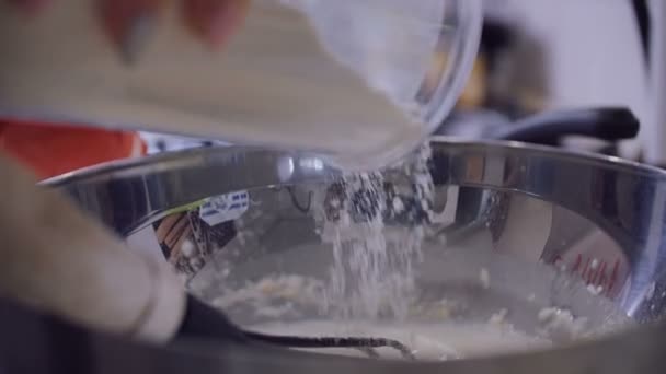 Eine Frau in der Küche gießt Pfannkuchenmehl in die Schüssel. — Stockvideo